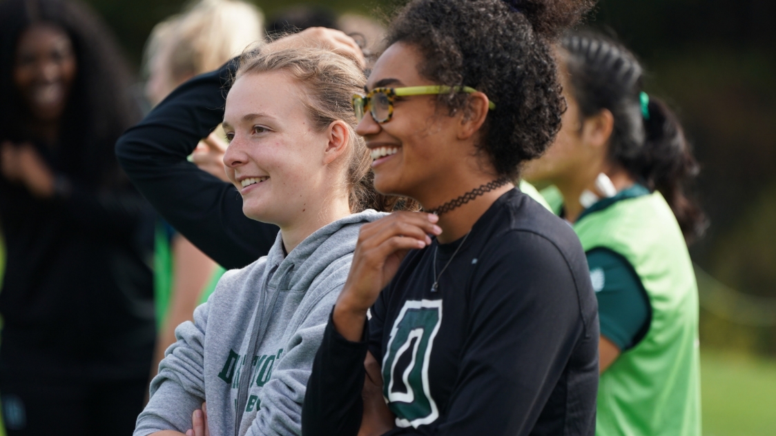 Two women athletes in Dartmouth apparel smiling