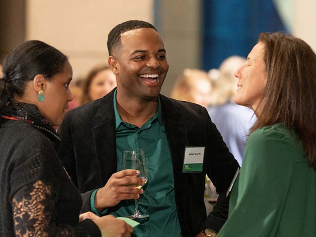 Three people talking at a causal event