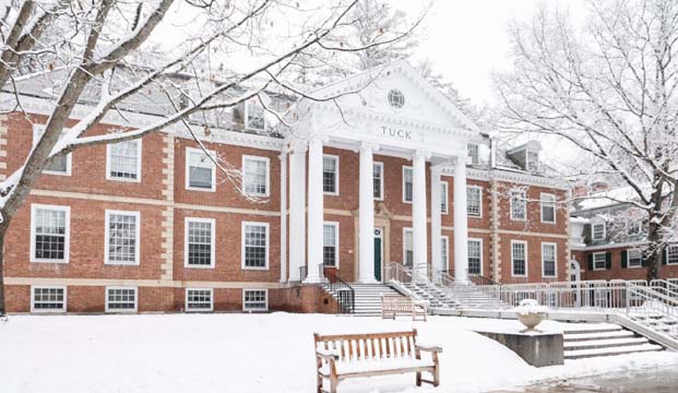 Photo of the Tuck building from outside with snow on the front lawn
