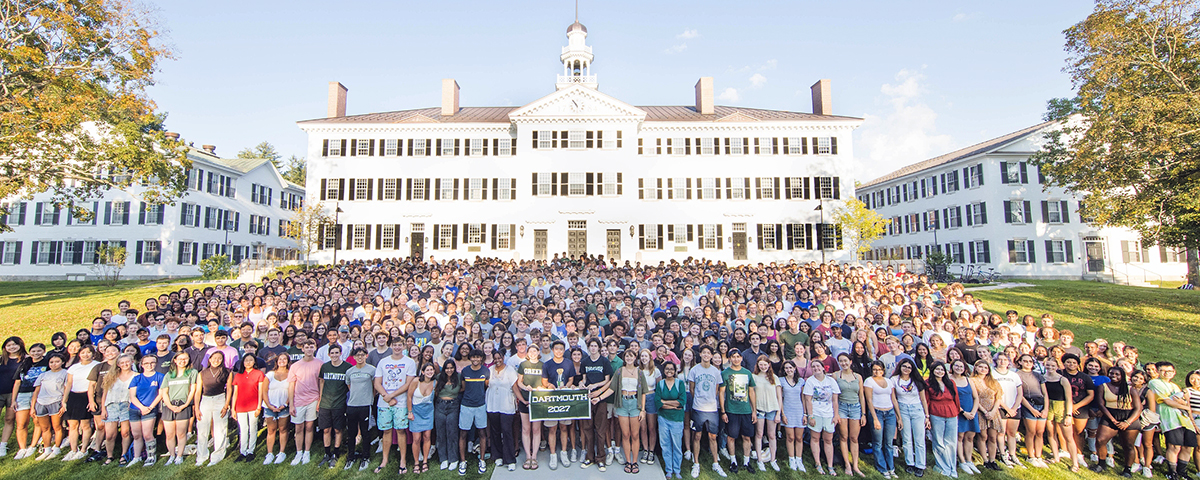 The Class of 2027 lined up on the Dartmouth Green for a class photo with Dartmouth Hall behind them.