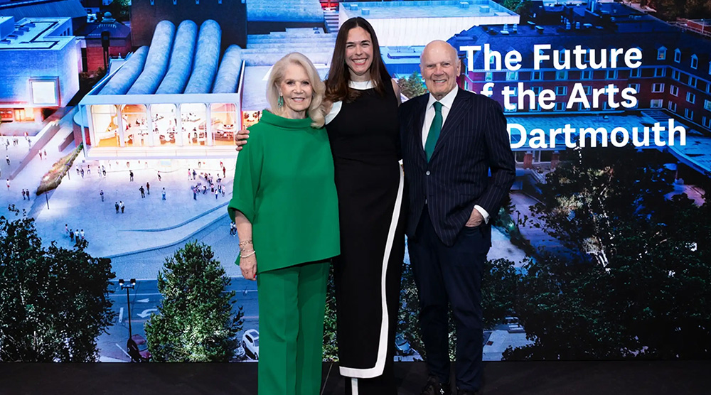 Daryl Roth, President Sian Beilock, and Steven Roth stand on stage in front of an rendering of the new Hopkins Center with the words The Future of the Arts at Dartmouth written on the image