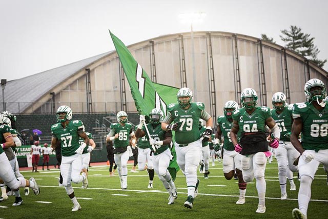 Members of the Dartmouth football team running on to the field on game day