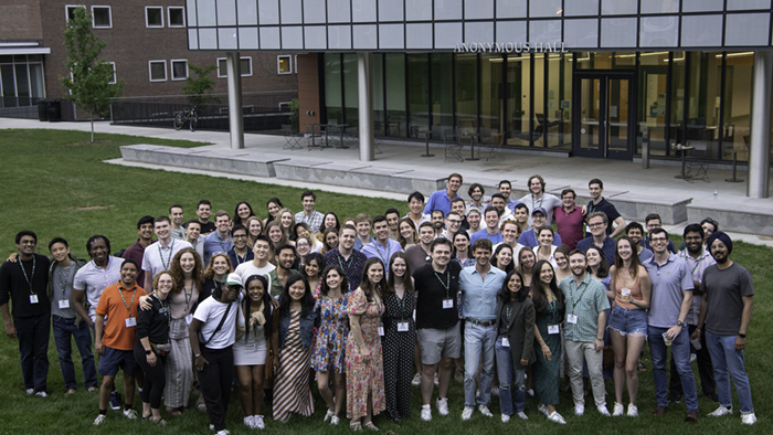 Group photo of the Class of 2018 in front of Anonymous Hall at 2023 Reunions