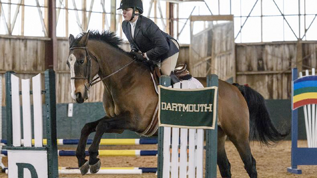 A Dartmouth equestrian rider jumps over an obstacle