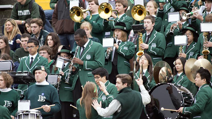 The Dartmouth Marching Band performs in the stands at a football game
