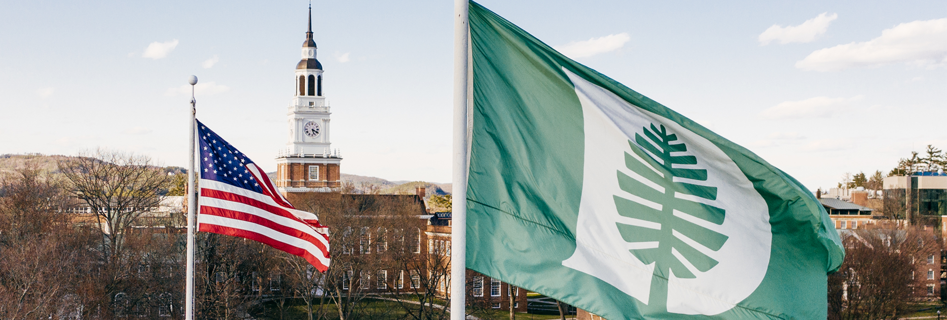 Dartmouth flag in the foreground, American flag in the middle ground, Baker Tower in the background
