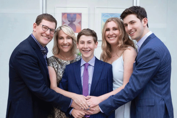 A picture of the Fagells posing with their three children at an event wearing formal wear and smiling. 