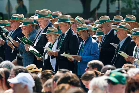 Class of 1977 members standing together wearing matching hats at commencement