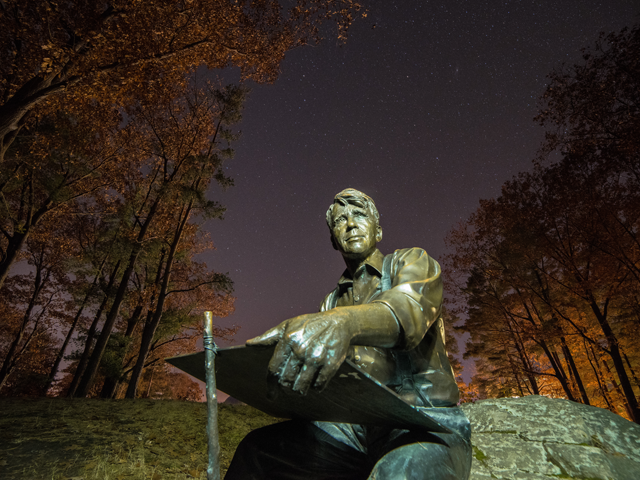 Shot from below of the Robert Frost statue at night