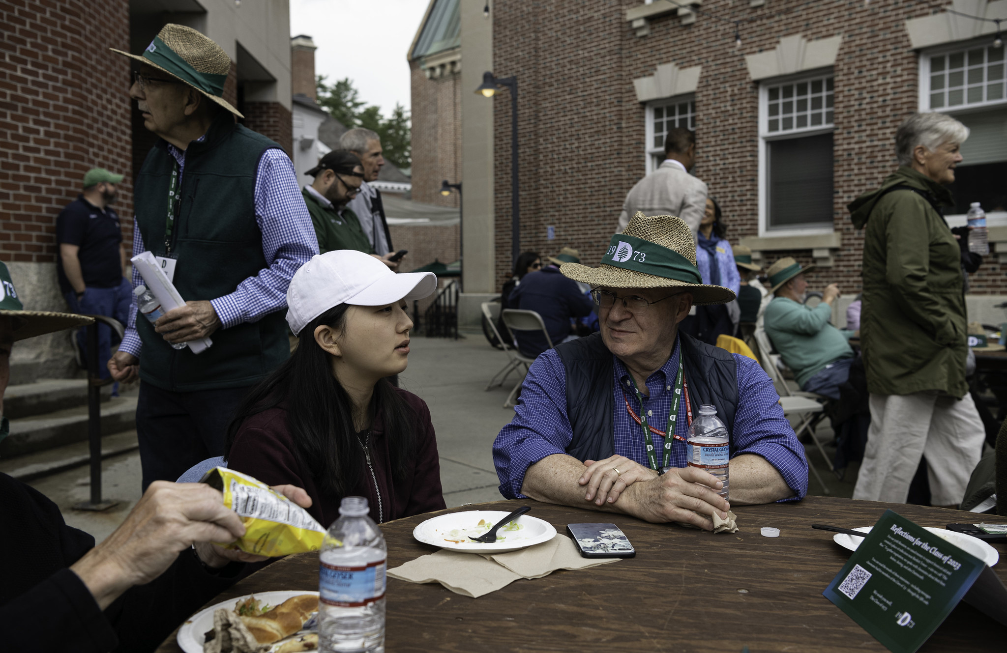 A pair of people sitting at the class of 23 luncheon outside of Collis.