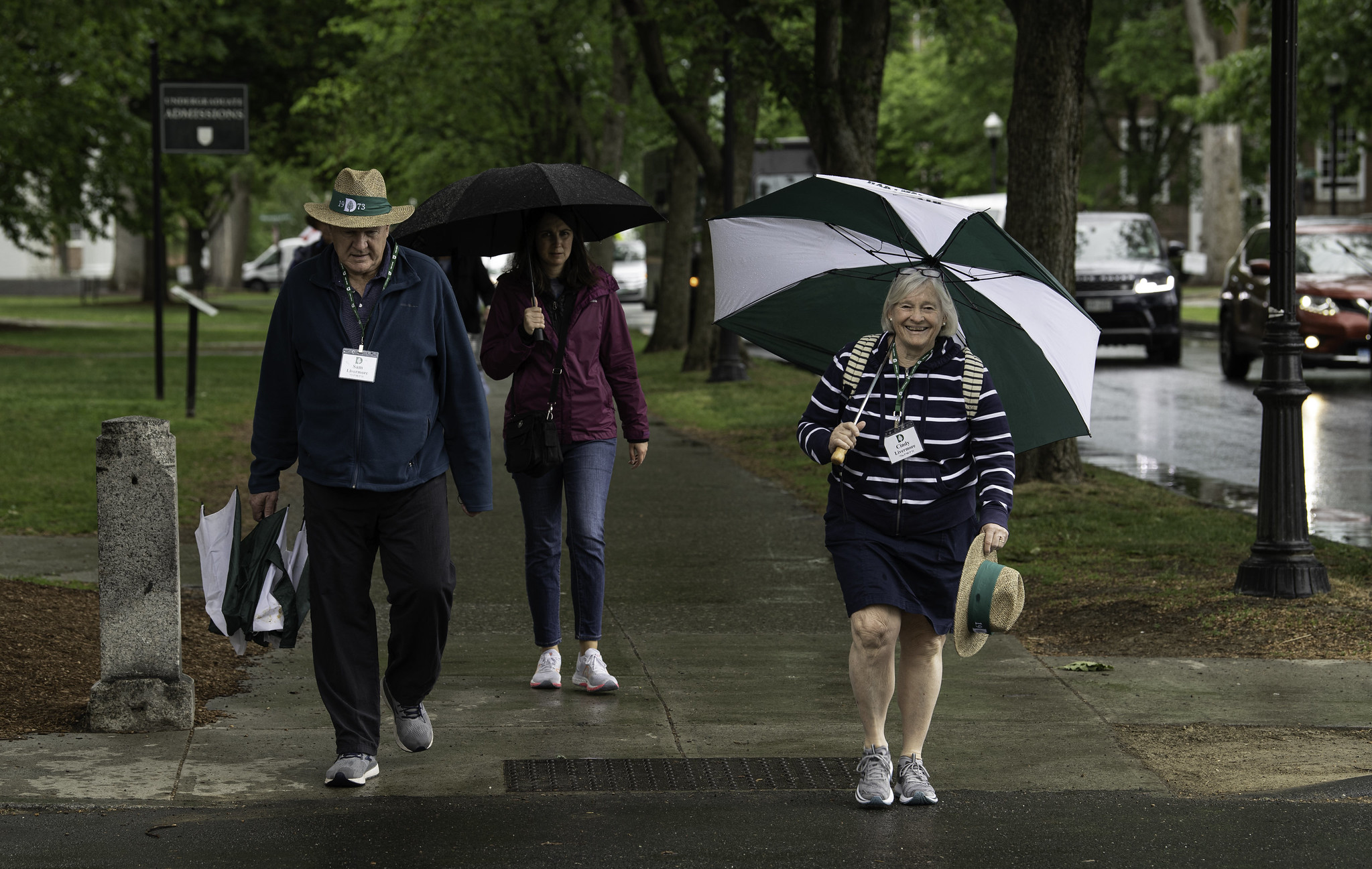 Reunion attendees walking with umbrellas. 