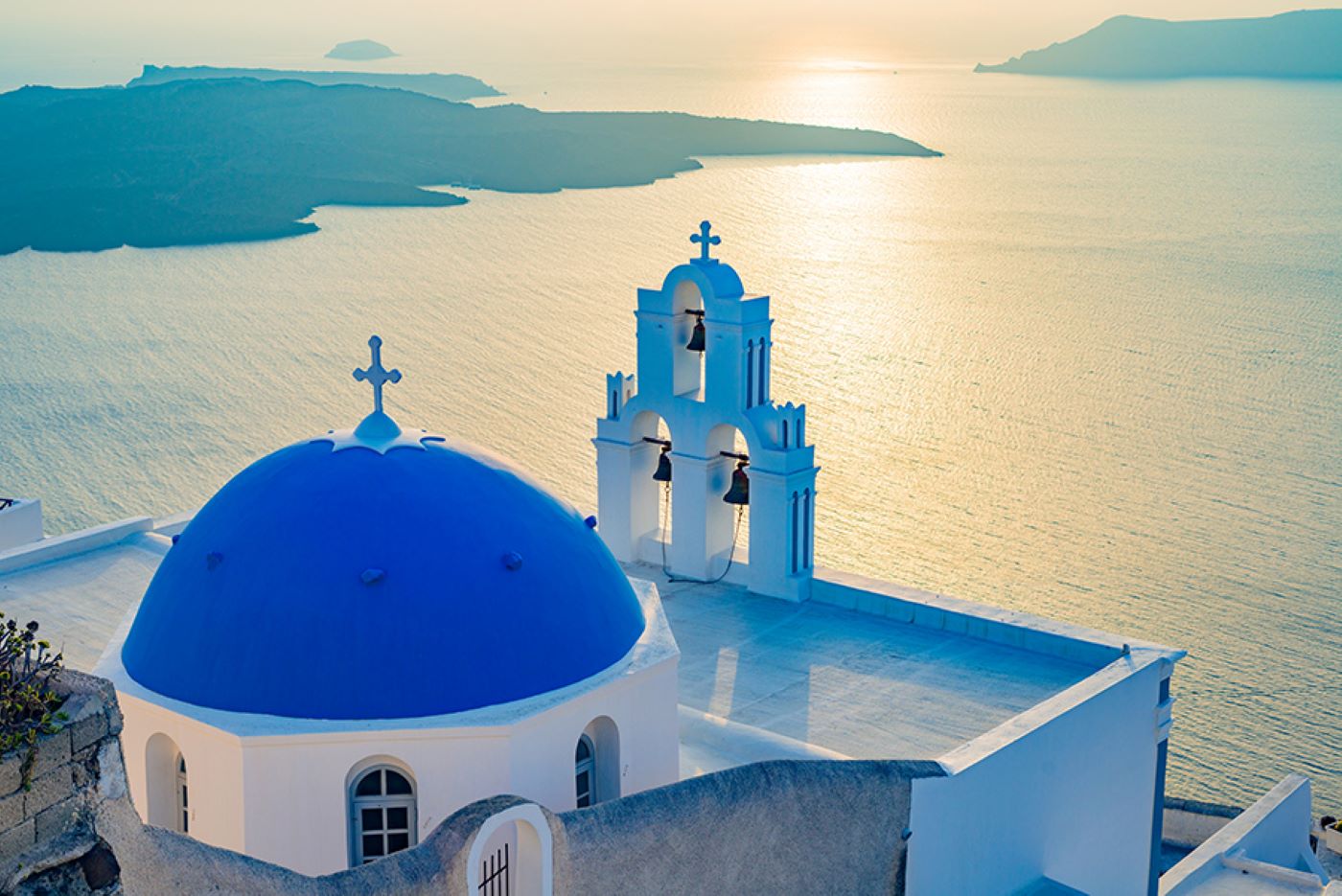View of blue dome and three bells of Fira in Santorini 