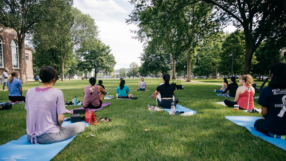 Students doing a yoga class on the Green