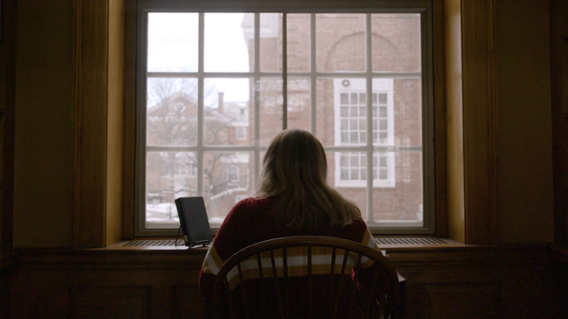 A shot behind Emma Johnson as she studies in front of a window