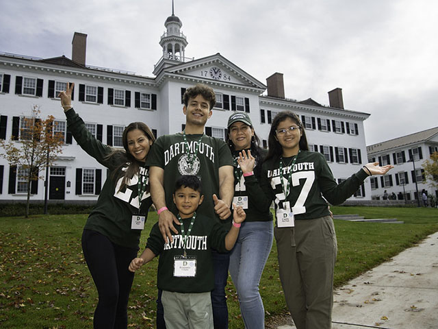 A Dartmouth student and his family posing in front of Dartmouth Hall