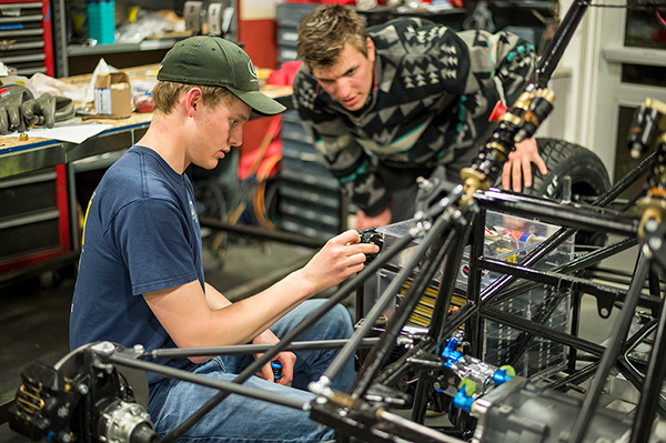 Two students working in the workshop fixing a bike