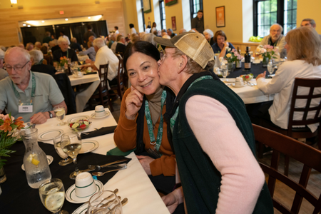 A person kissing another person on the cheek at a reunion event.