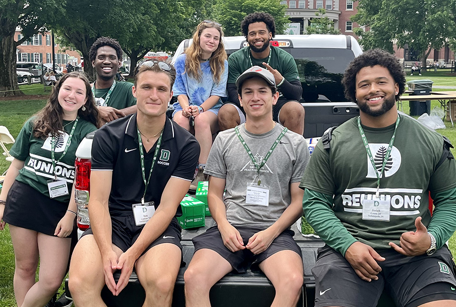 Reunions student workers sit on the back of a truck to pose for a photo