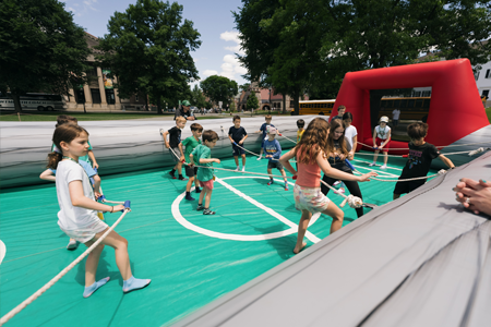 Kids playing tug of war on inflatable at Reunions 2024