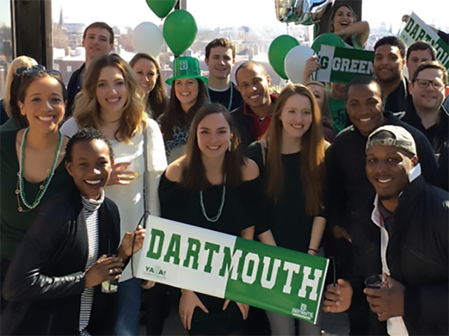 Young alumni holding dartmouth banners celebrating together at a Big Green Affair