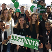 Young alumni holding dartmouth banners celebrating together at a Big Green Affair