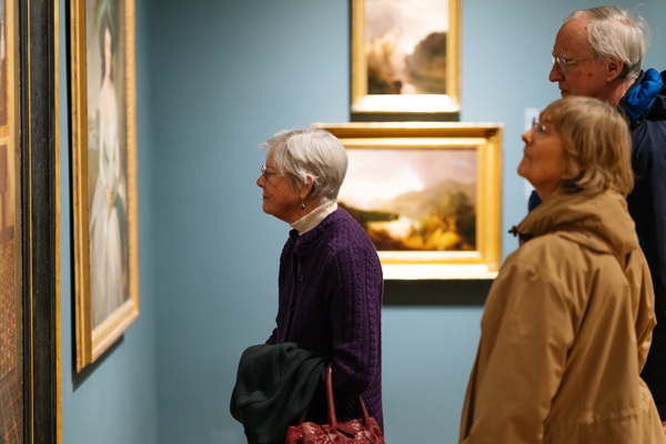 Elderly friends looking at paintings in an art museum