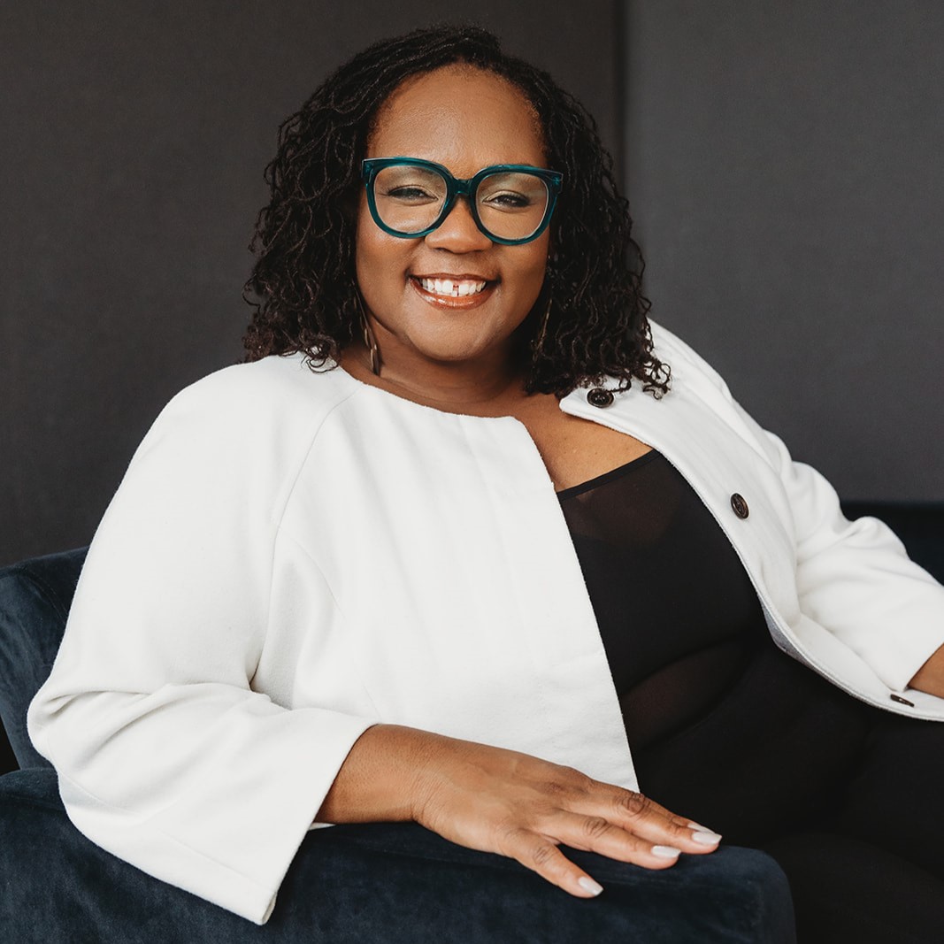 Shontay Delalue smiling and sitting in a chair