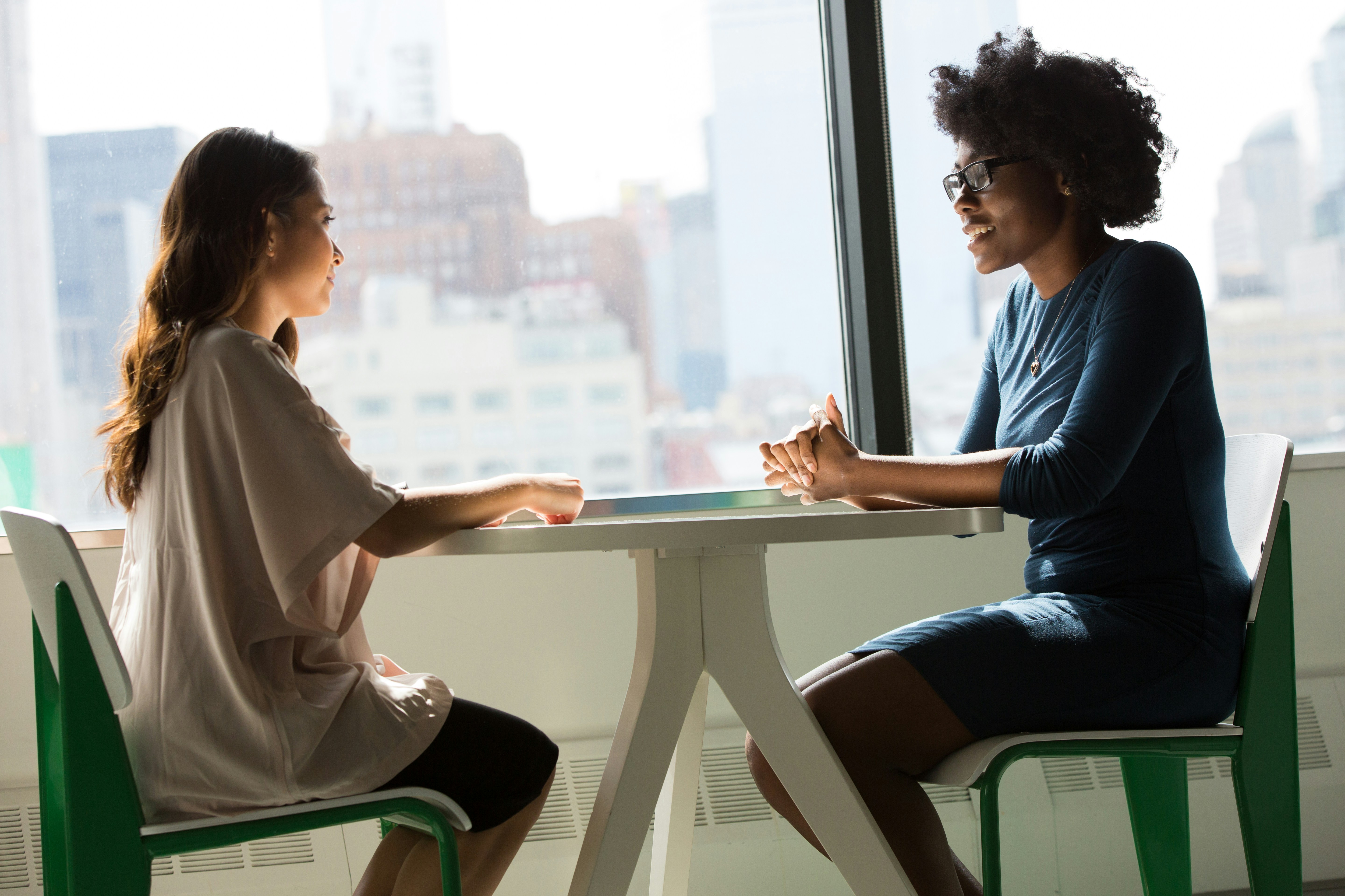 Two people seated at a table having a conversation