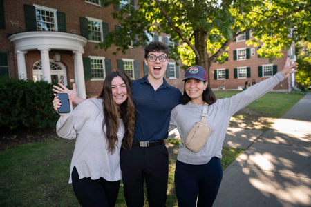 Happy students posing for a photo. Their arms are outstretched with excitement.