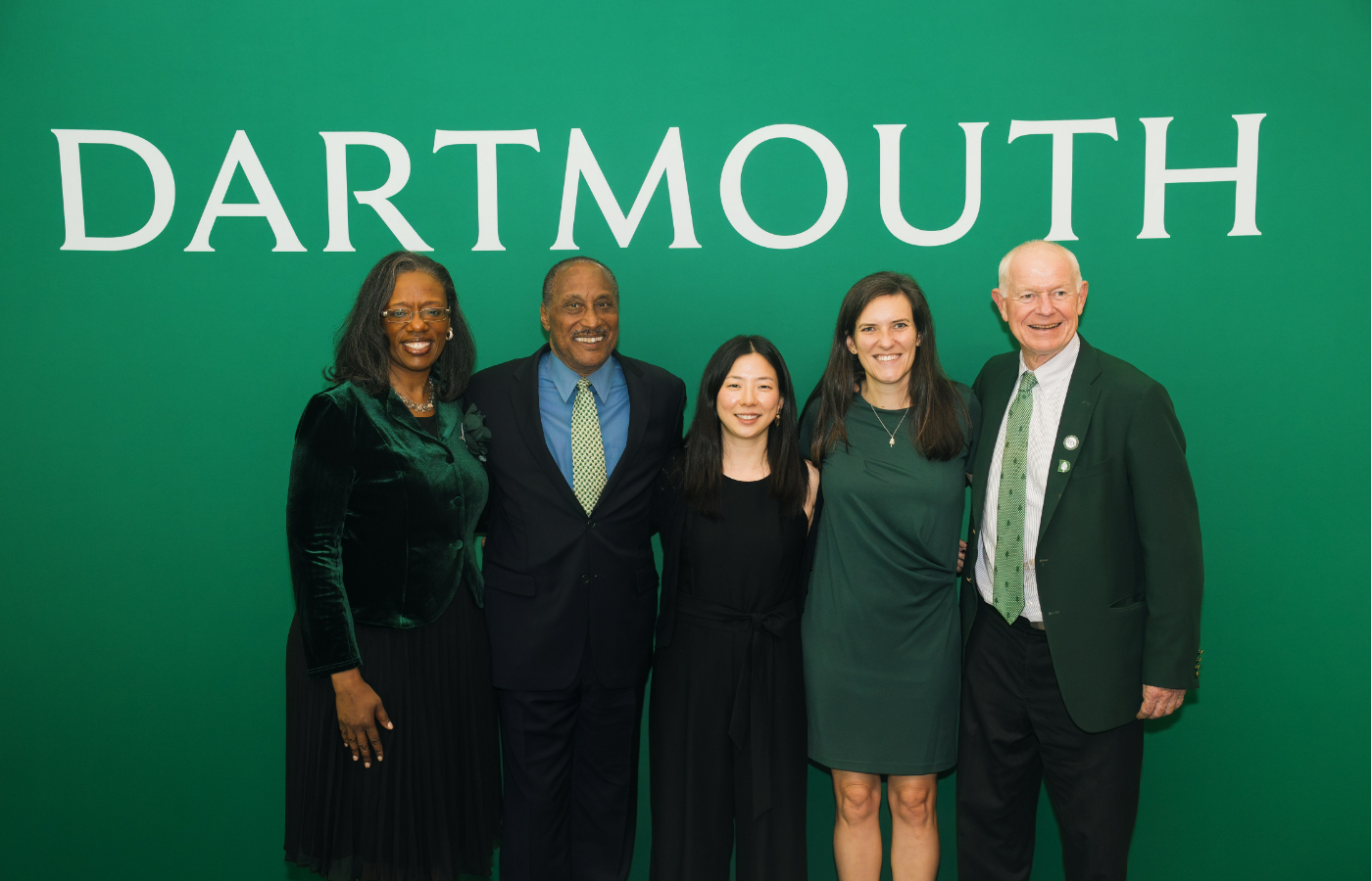 The winners of the 2024 Alumni Council awards posing in front of a green backdrop that reads Dartmouth.