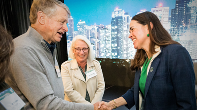 President Sian Beilock shaking the hand of a man while another woman off to the side smiles.