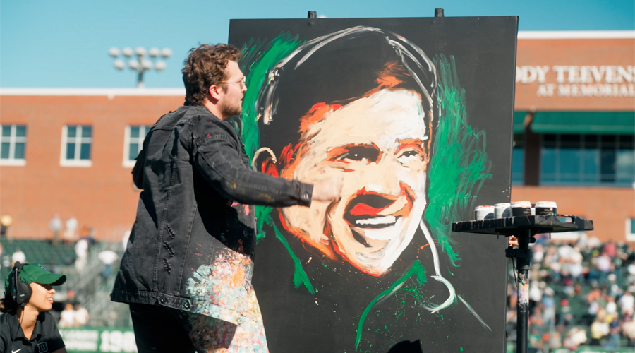 Speed fingerpainter working on a portrait of Buddy on the field