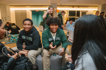 Two students in Dartmouth gear in a residence hall. 