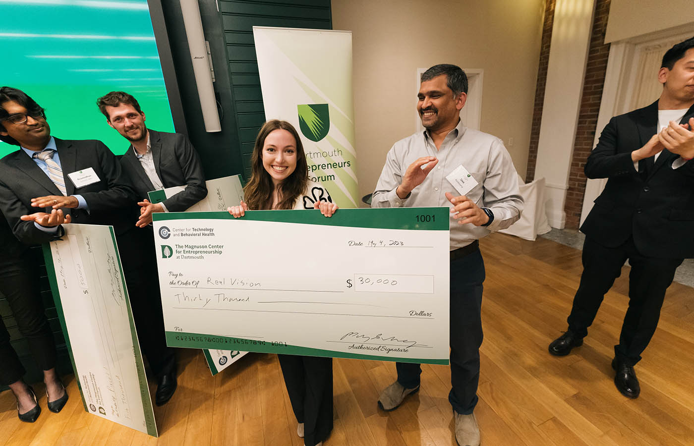 A photo of Dartmouth student Julia Hill holding a check for 30,000 in funding for RealVision