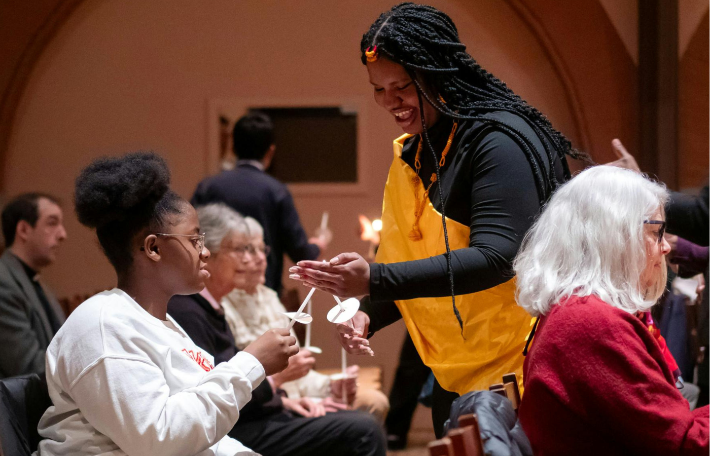 Two students lighting candles at Rollins Chapel. 