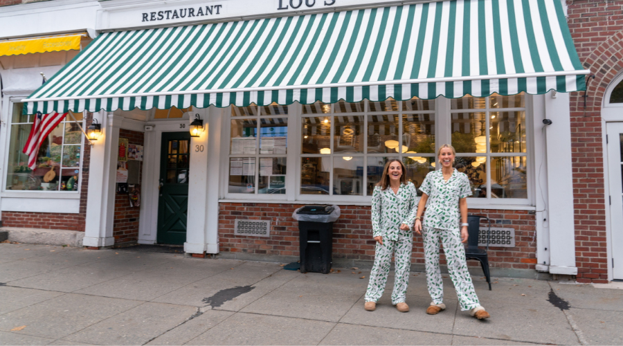 Two students wearing pajamas outside of Lous.