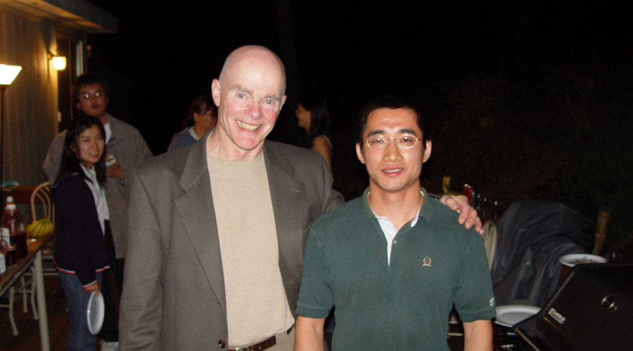 An alum and former professor posing together. 