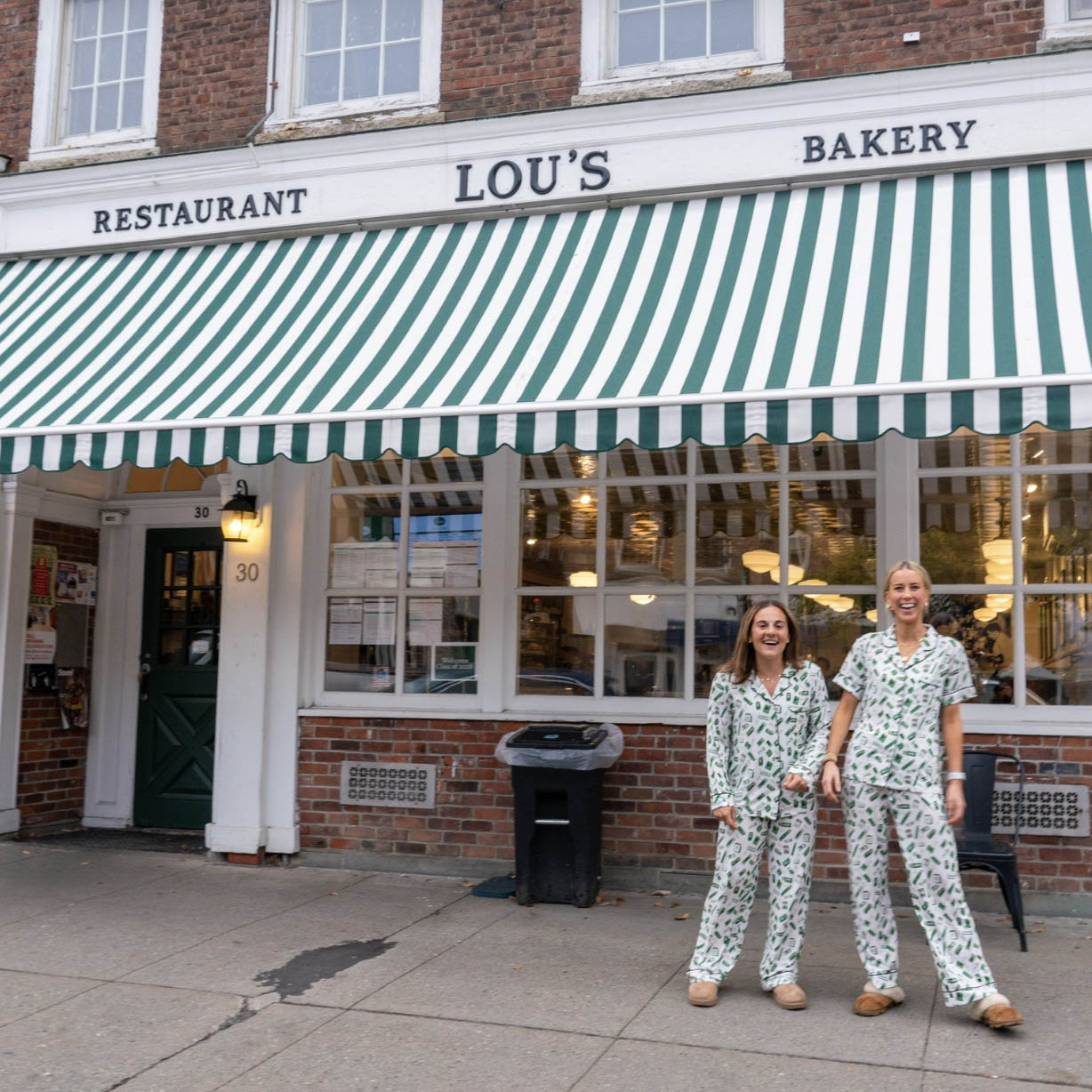 Katie Weber ’24 and her sister Madelyn, two young entrepreneurs, posing in front of Lou's Restaurant and Bakery