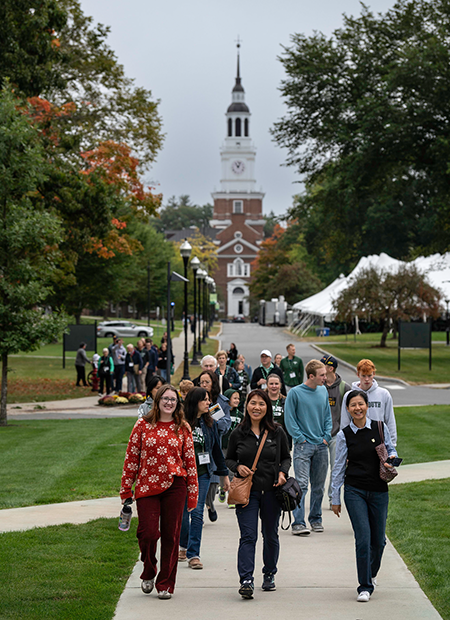 Families walking along sidewalk path with Baker Tower in the background