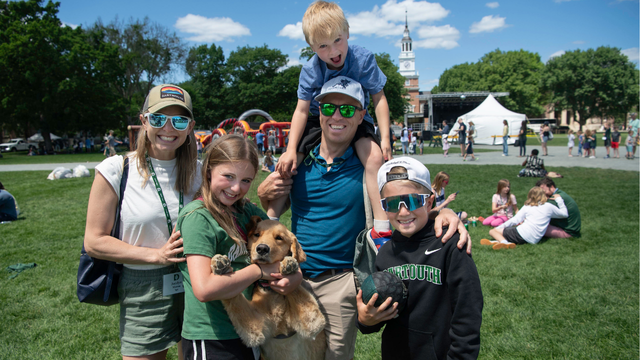 A family with three children and a dog posing on the Green during Reunions. 