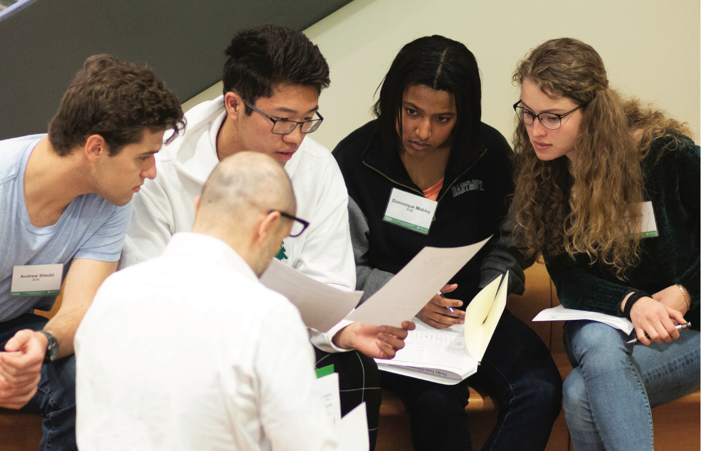 An advisor and students working together looking at documents.