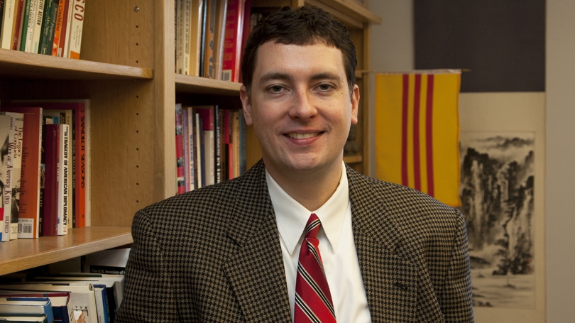 Ed Miller sitting in front of bookshelf