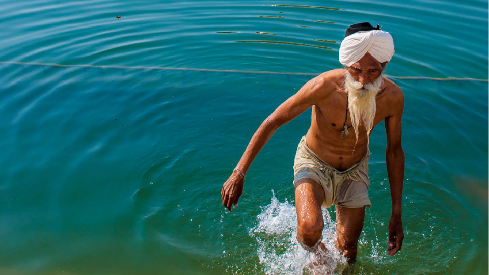 A man bathing in the water at the Golden Temple in Armritsar, India.