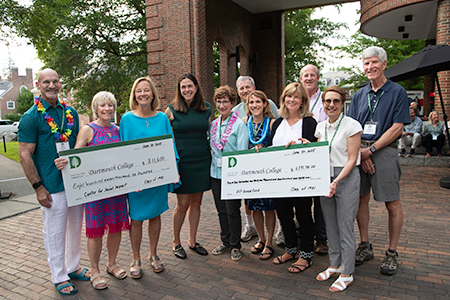 Members of the Class of 1981 holding a pair of checks with President Beilock
