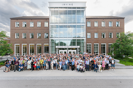 Members of the Class of 1980 pose for a class photo in front of the Irving Institute