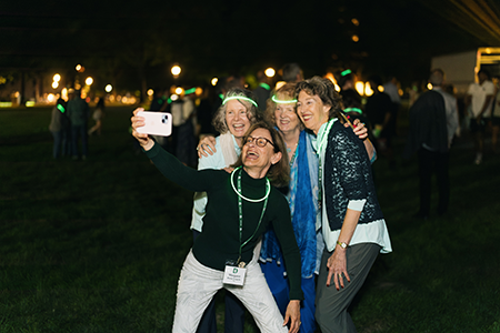 Alums posing for a selfie on the green