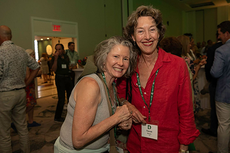 Two women at a reunions event smiling and posing together