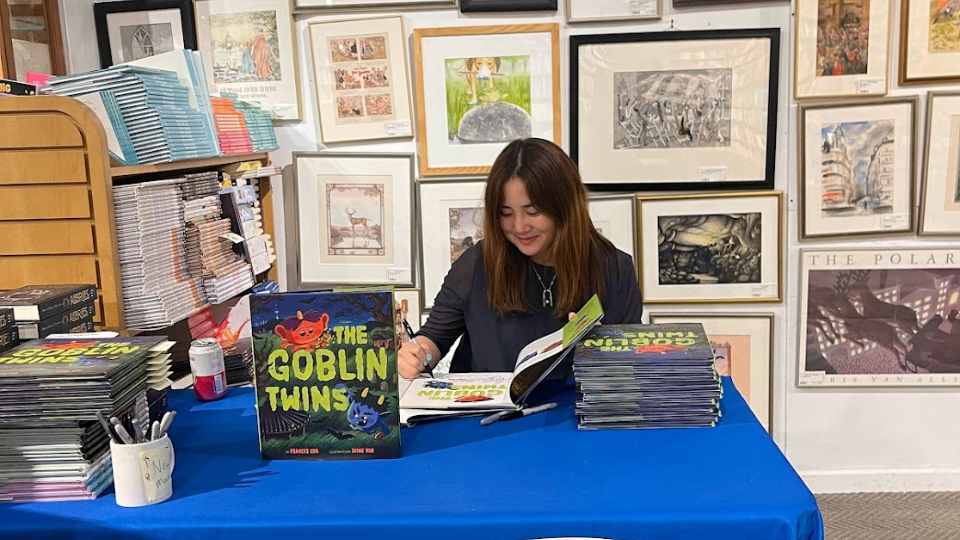 Author Frances Cha 07 at a book signing for her children's book.