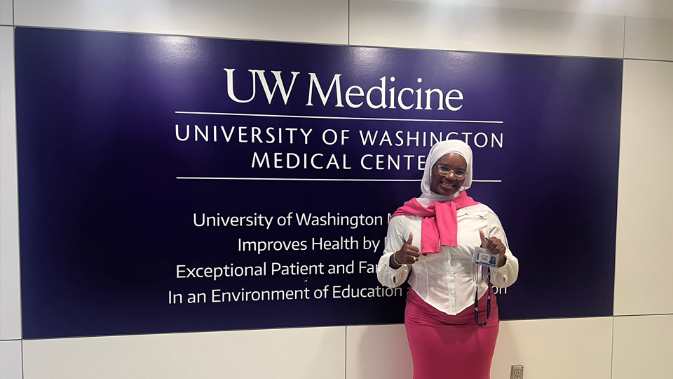 Oumie Fatty-Hydara standing in front of UW Medicine sign