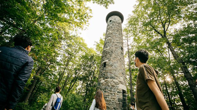 A group of people looking up at Bartlett Tower on a sunny day.
